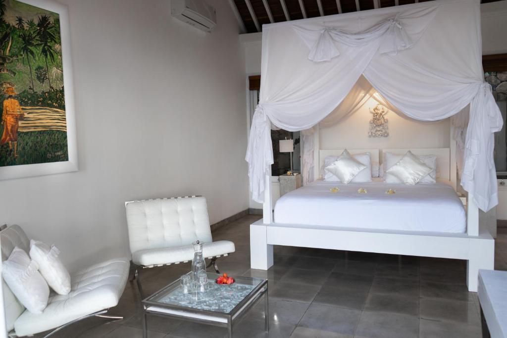 Bed with char at Shunyata Villas Bali