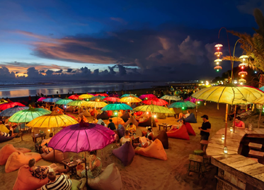 Evening beach scene with colorful umbrellas in Seminyak