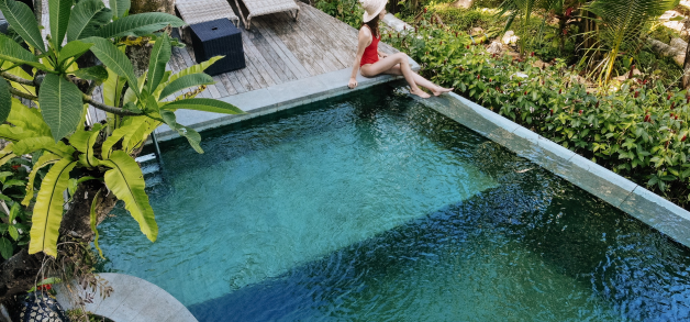 Woman relaxing by a private pool in a tropical villa