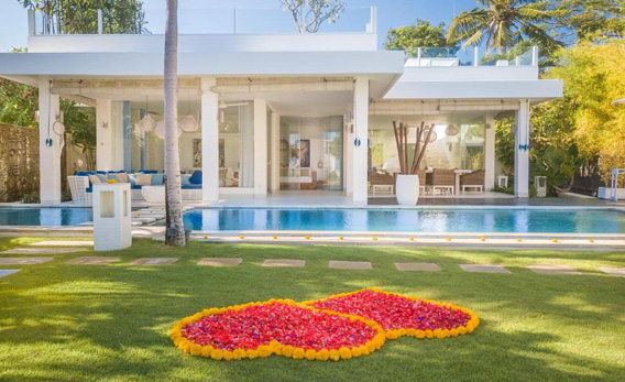 Luxury honeymoon villa in Canggu with private pool, white modern architecture, and flower decorations on the lawn