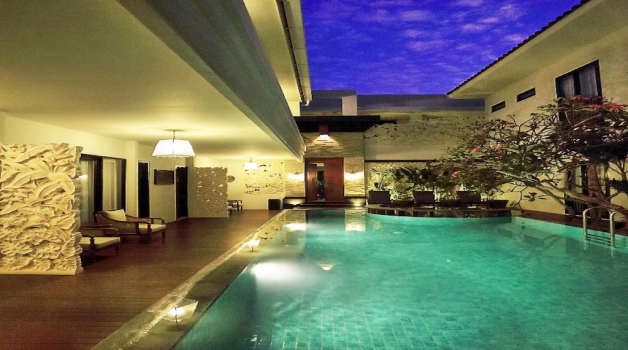 Luxury villa with an illuminated pool at night