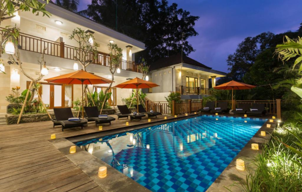 Poolside villa with lounge chairs and orange umbrellas.