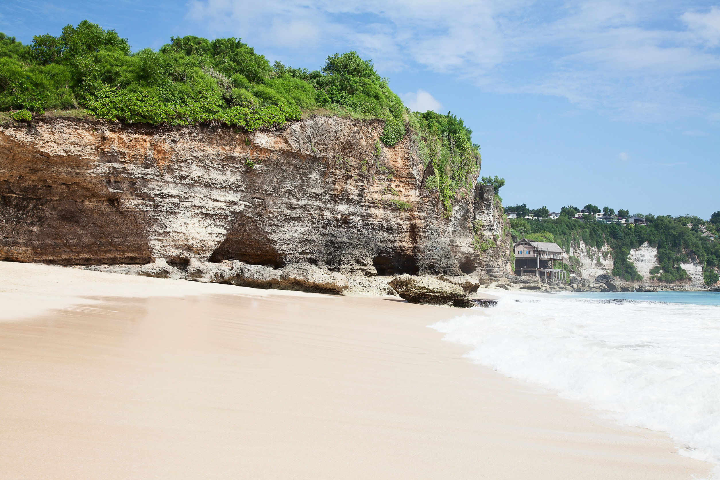 Sandy beach with cliffs and greenery