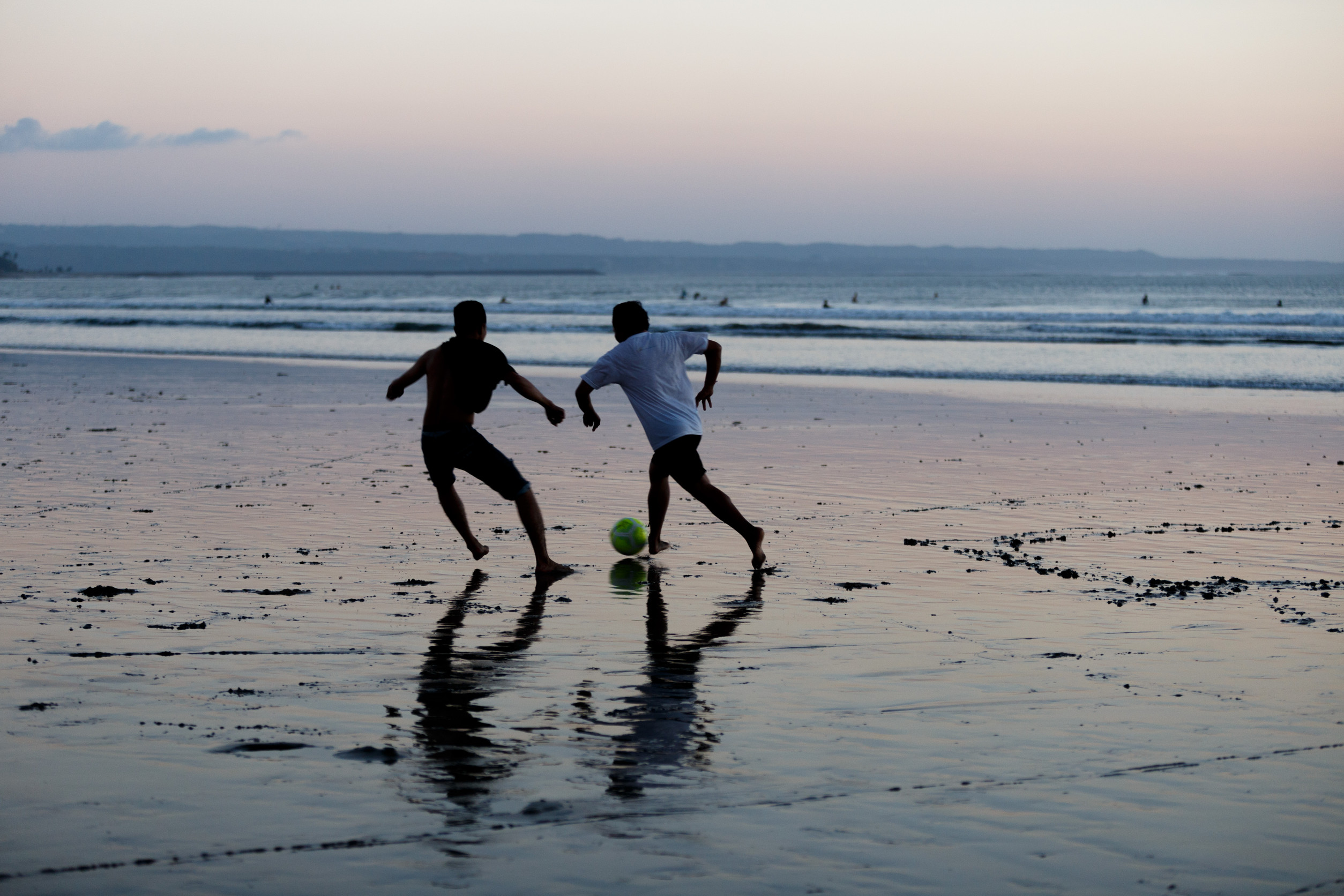 People playing football on the beach