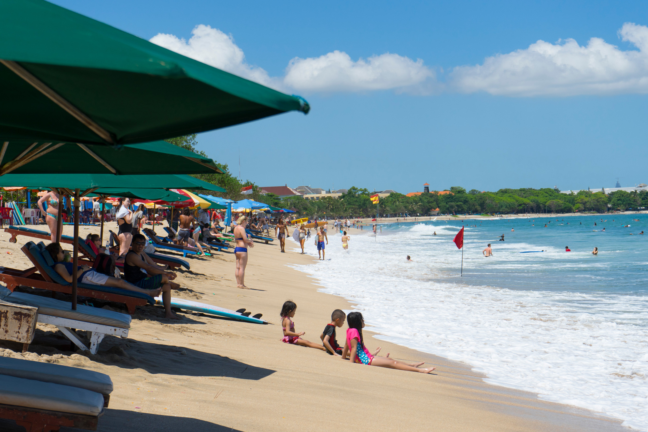 Kids sitting and playing in the sand on Kuta Beach