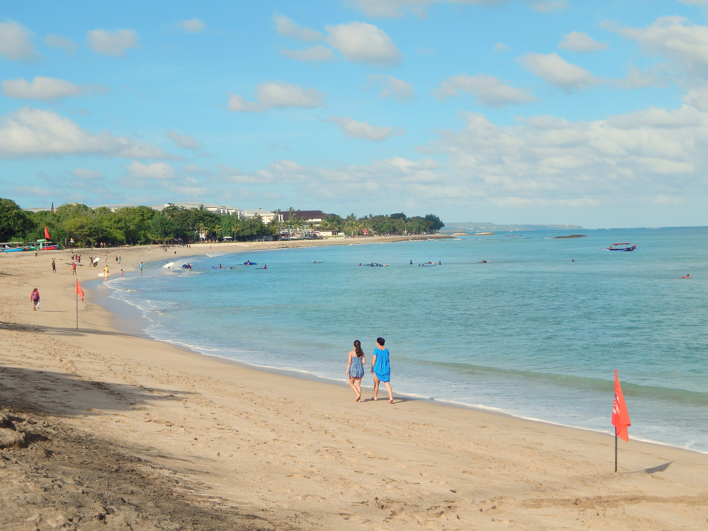 Couples walking hand in hand along the beach