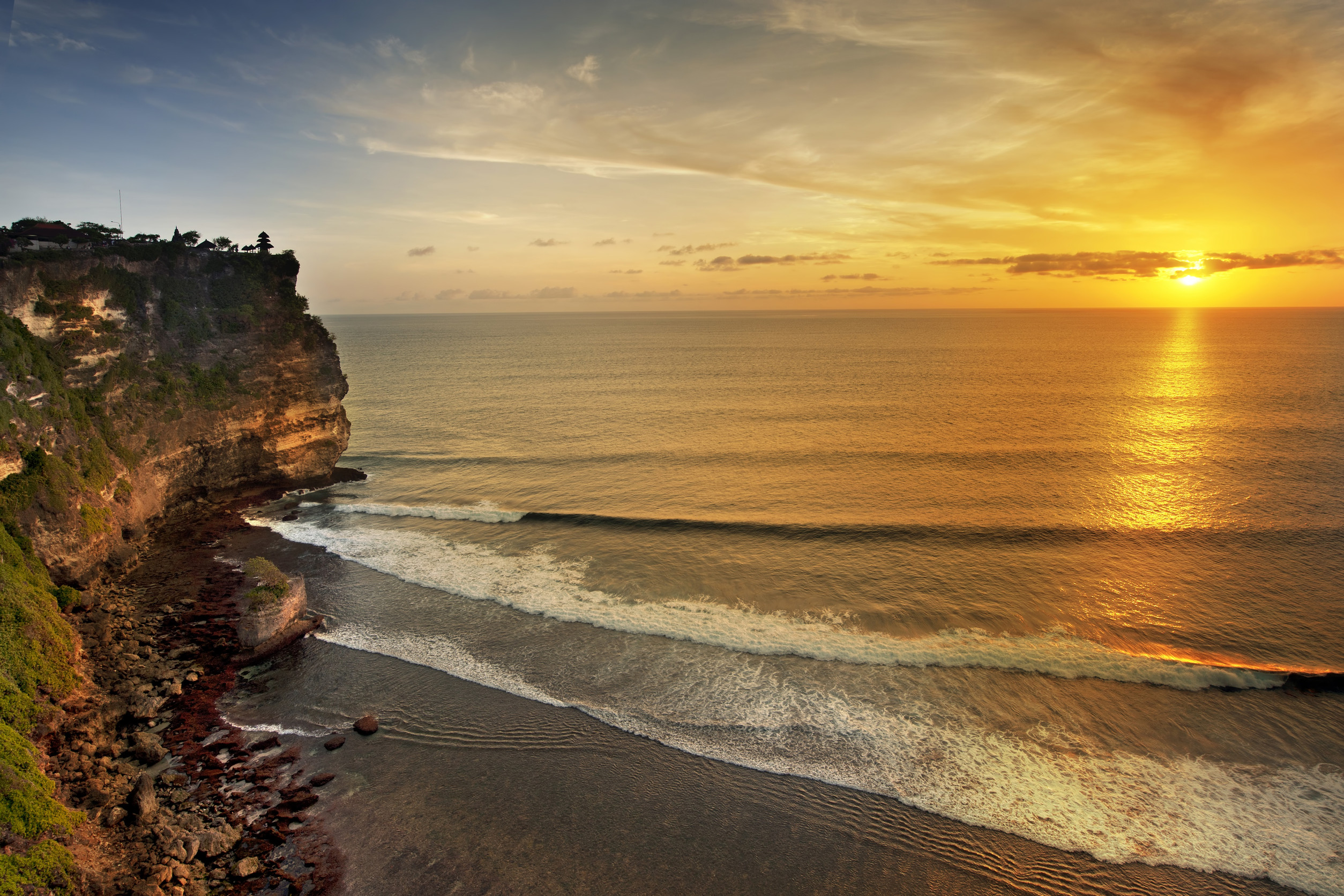 Golden sunset over cliffs and ocean waves