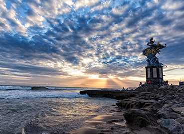 Stunning sunset view with a statue along the shoreline at Pererenan Beach