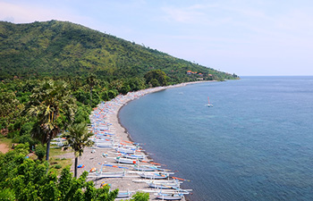 Aerial view of curved beach and fishing boats in Amed