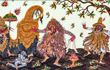 Colorful Balinese shadow puppets displayed on a textile backdrop