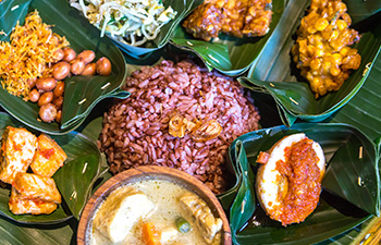 Balinese food served in banana leaf bowls with rice and side dishes