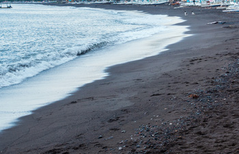Dark sand beach with gentle waves