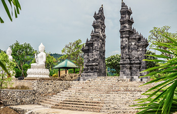 Hot spring pools with carved stone statues and people bathing
