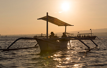 Silhouetted fishing boat during sunrise