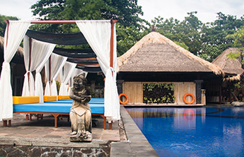 Eco-resort with open-air cabanas surrounding a swimming pool