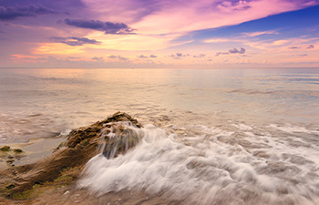 Foamy waves crashing at sunset on a remote beach