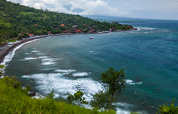 Cliffside villas overlooking blue ocean and green hills