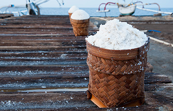 Basket of sea salt on a wooden table at a salt farm