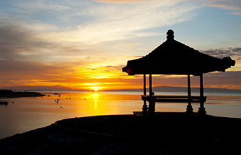 Traditional beach gazebo with the sun rising behind it