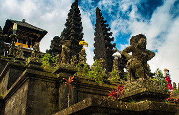 Ancient Balinese temple with tiered towers and guardian statues