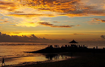 Silhouette of people on a pier at sunset