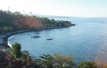 Ocean-side road with volcanic hills and calm sea