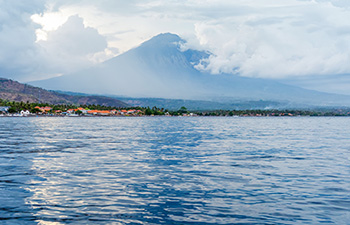 Mount Agung seen across the calm ocean from Amed