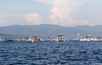 Boats floating on water with distant hills