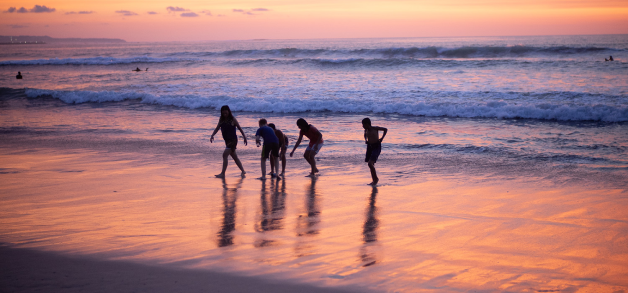 Children playing on the beach at sunset