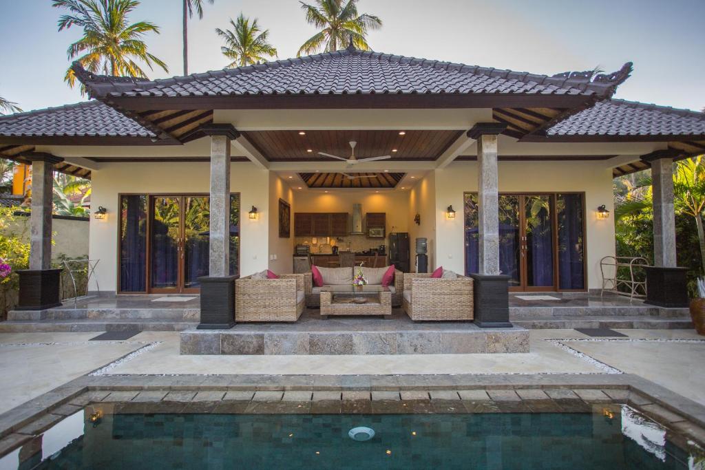 Villa with a porch, pool, and palm trees