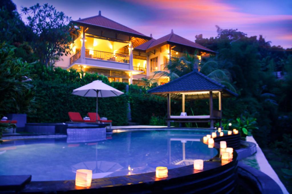 Villa with candlelit pool at dusk