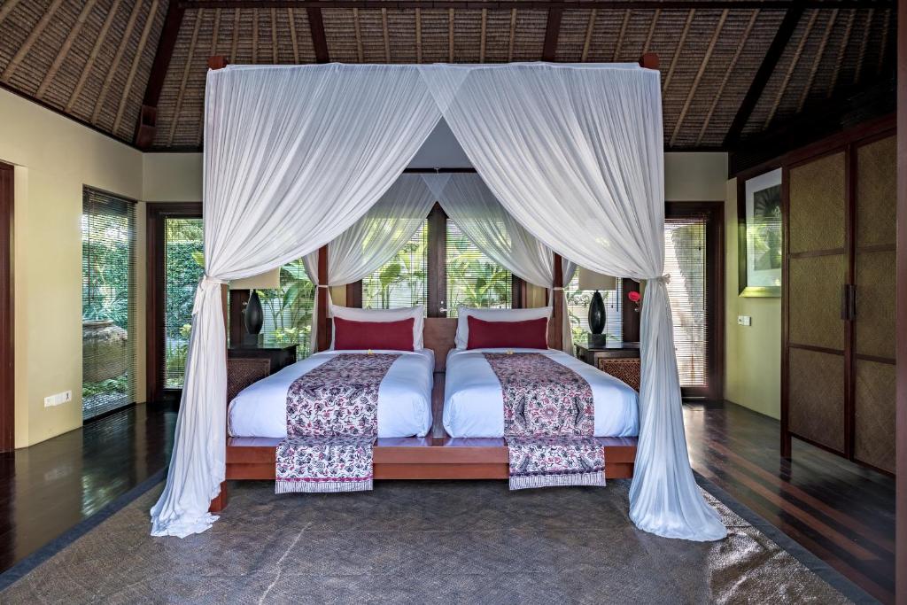 Spacious bedroom with four-poster bed and greenery