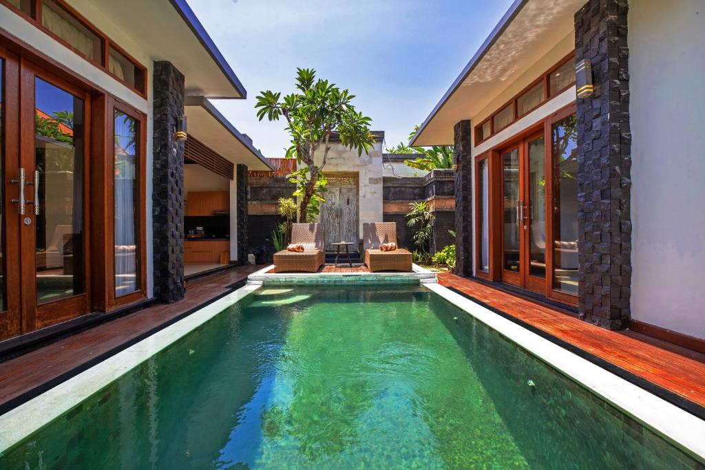 Private villa pool with loungers and tropical plants