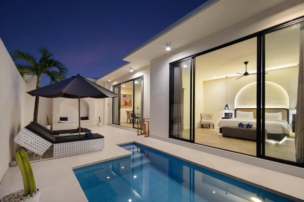 Contemporary villa with poolside seating under an umbrella